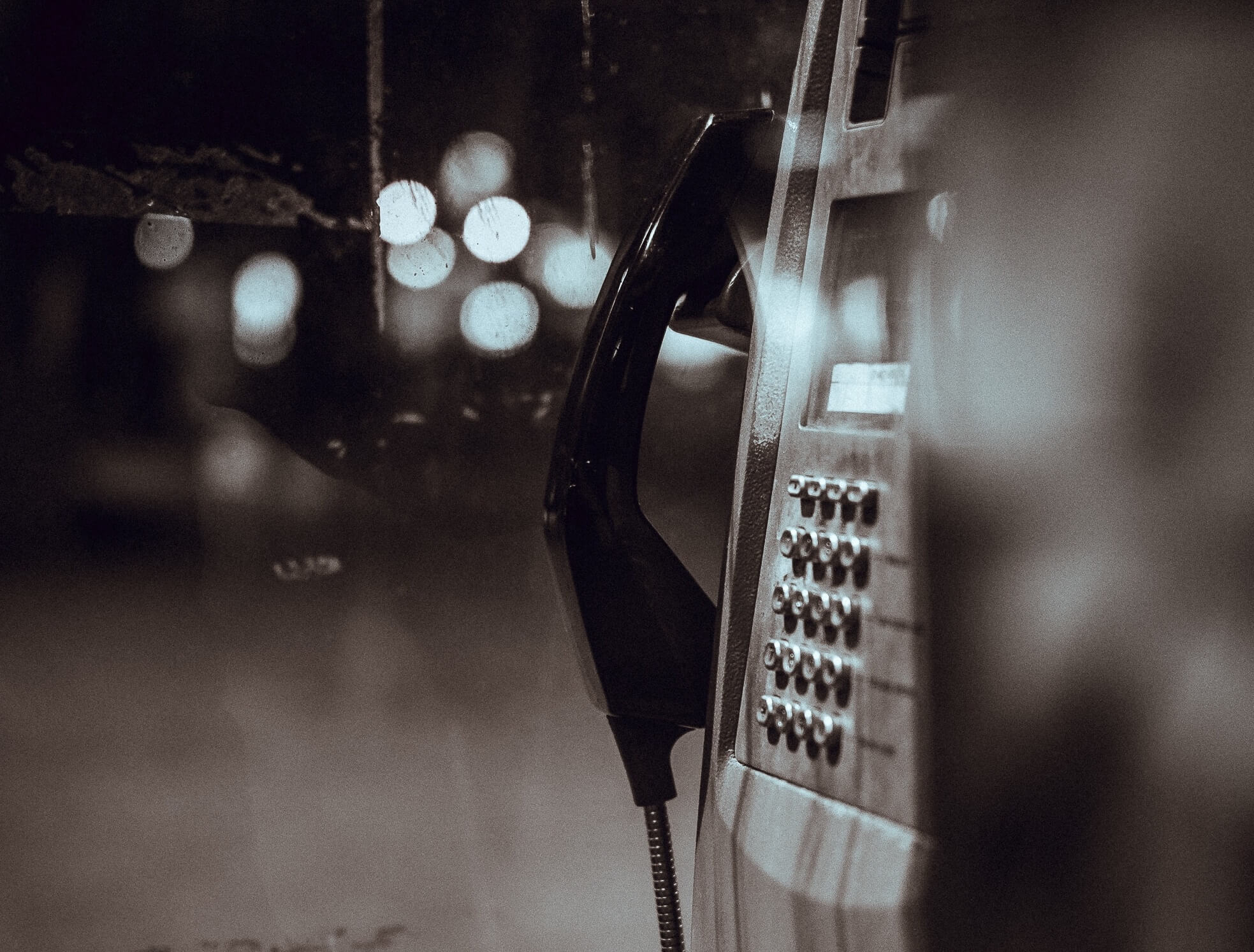 Black and white image of telephone outside in the dark