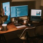 a desk with a set of three computer monitors