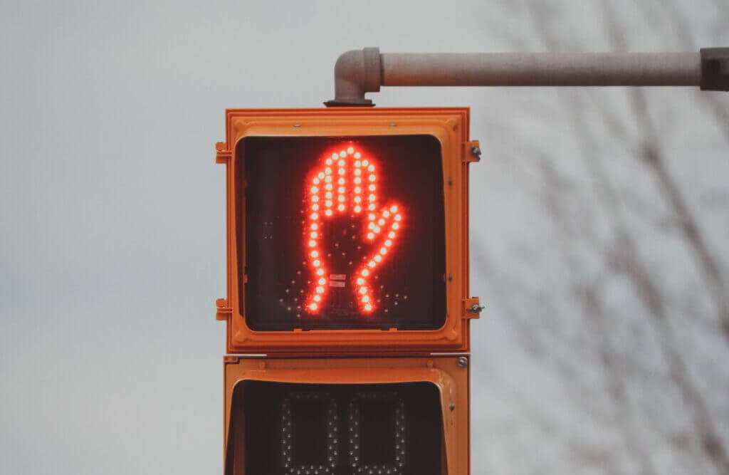 Pedestrian crossing signal with red hand signalling stop