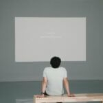 Person gazing at blank white canvas on wall