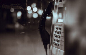 Black and white image of telephone outside in the dark