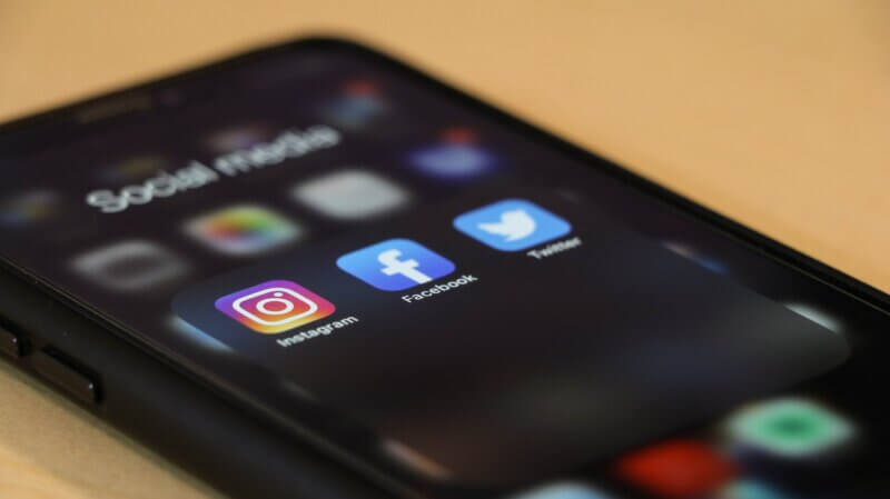 smartphone showing instagram, facebook and twitter icons