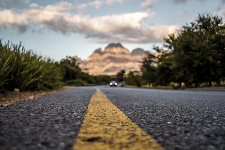 Close up of a road stretching on toward a small mountain