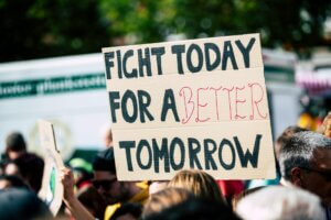 A sign held aloft at a protest reading: FIGHT TODAY FOR A BETTER TOMORROW
