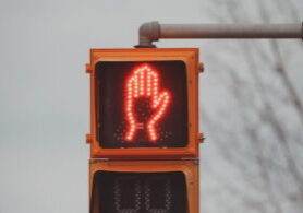 Pedestrian crossing signal with red hand signalling stop